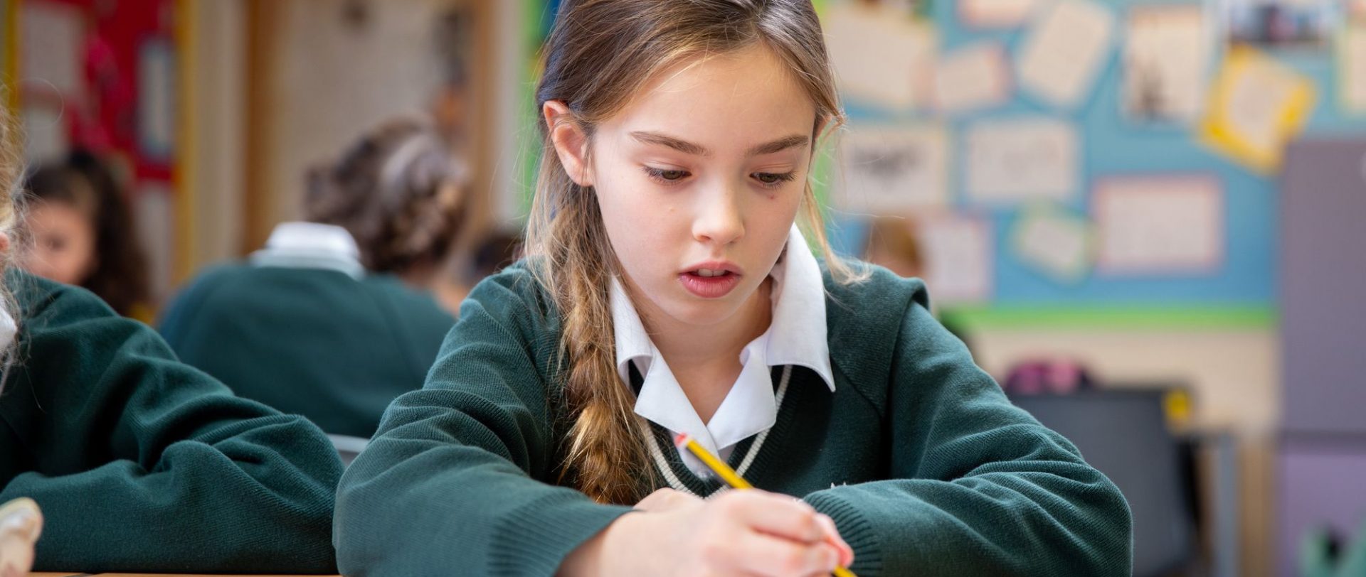 school girl writing with a pencil