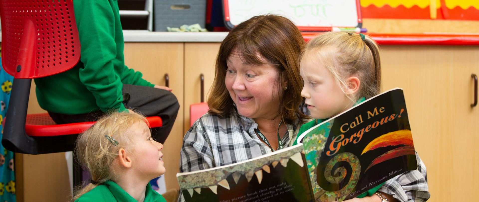 teacher reading a story to early years students