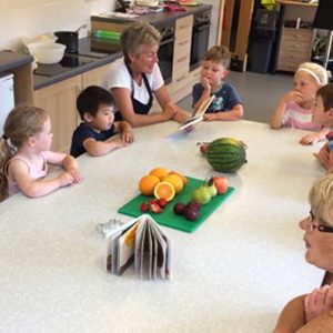 students look at a pile of fruit and veg