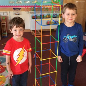 students next to a k'nex building