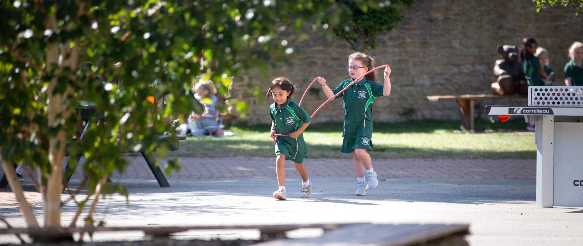 two young girls outside with a skipping rope