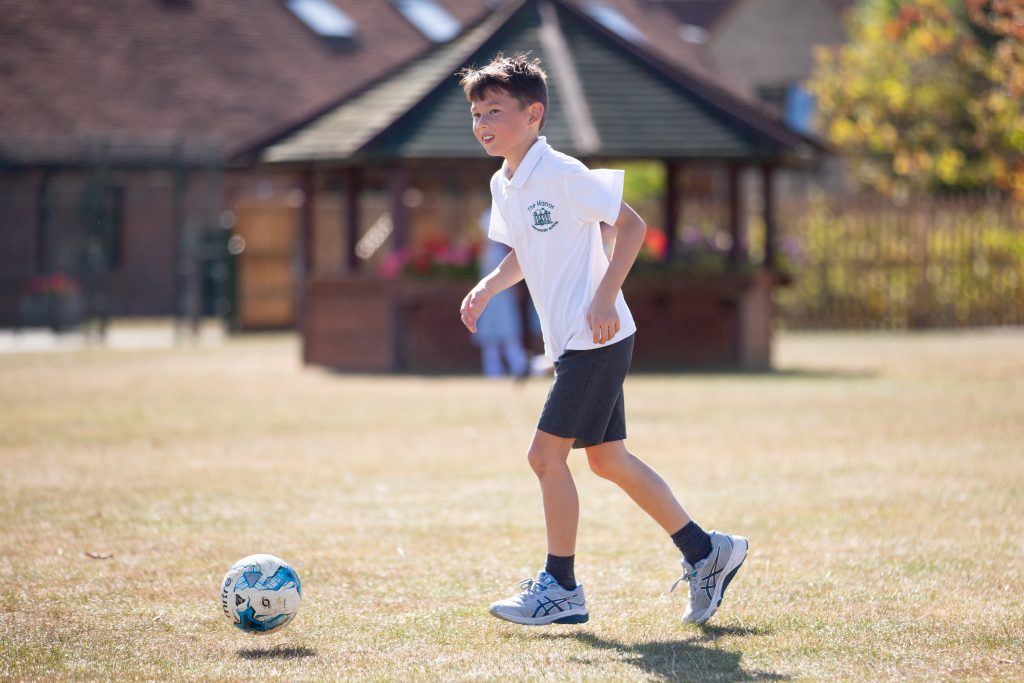 Manor Prep student kicking a football