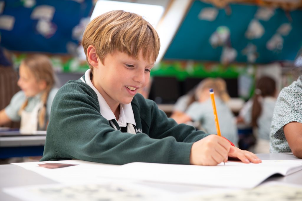 Prep school student writing into their booklet