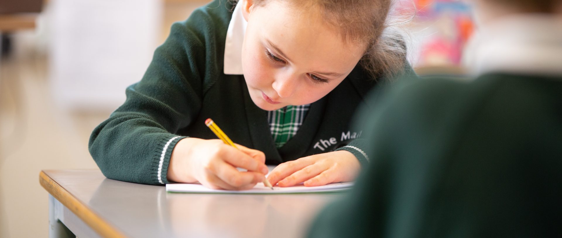 school girl writing with a pencil during lessons